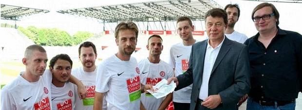 Otto Rehagel überreicht dem Perspektiv-Team rund um Trainer Benjamin DeBiasi Freikarten für das Spiel der ersten Mannschaft von Rot-Weiss Essen gegen Werder Bremen.